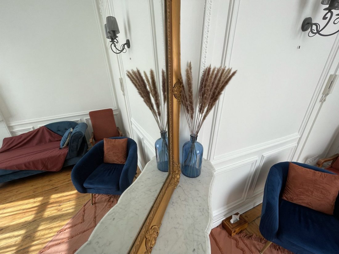 Miroir doré et vase de roseaux séchés dans le cabinet